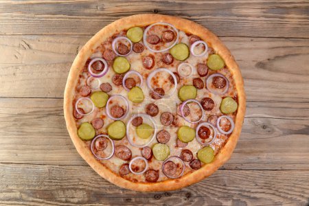 Téléchargez les photos : Délicieuse pizza maison avec saucisses et concombres marinés - en image libre de droit