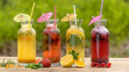 Foto de Bebidas refrescantes con bayas, frutas y pajitas - Imagen libre de derechos