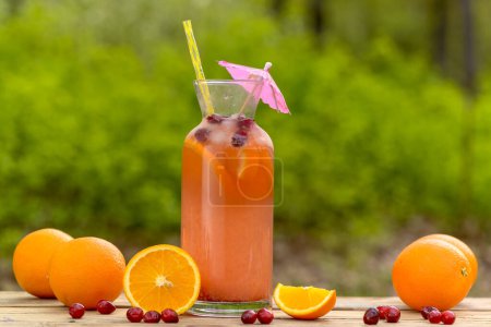 Photo for Glass with tasty fresh orange and cranberries cocktail on table - Royalty Free Image
