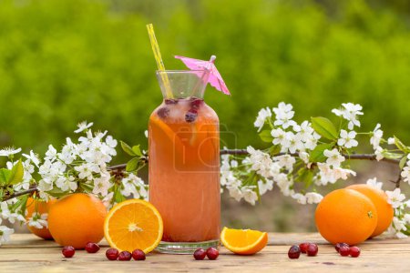 Foto de Vaso con sabroso cóctel de naranja fresca y arándanos en la mesa - Imagen libre de derechos
