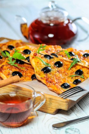 Photo for Delicious pizza with black olives and tea on table close - up - Royalty Free Image