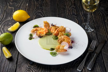 Téléchargez les photos : Crevettes frites dans une assiette avec des verts et du radis - en image libre de droit