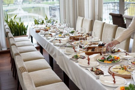 Téléchargez les photos : Une grande table avec des plats dans un restaurant et une femme - en image libre de droit