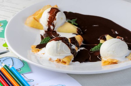 Foto de Tortitas con helado cubierto de chocolate en un primer plano plato blanco - Imagen libre de derechos