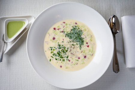 Téléchargez les photos : Soupe okroshka froide dans une assiette blanche sur un fond blanc - en image libre de droit