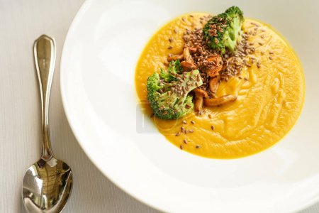 Photo for Pumpkin cream soup with broccoli and mushrooms sprinkled with seeds - Royalty Free Image
