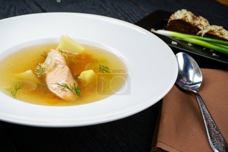Téléchargez les photos : Soupe de saumon aux légumes dans une assiette blanche et pain - en image libre de droit