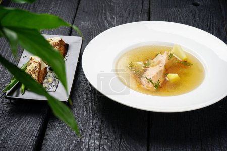 Photo for Salmon soup with vegetables in white plate and bread - Royalty Free Image