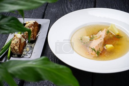 Photo for Salmon soup with vegetables in white plate and bread - Royalty Free Image