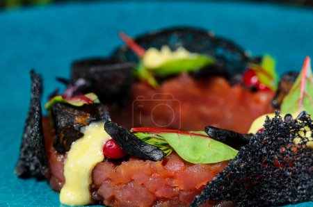 Photo for Fresh fish   tartare  and salad leaves on a black background. - Royalty Free Image
