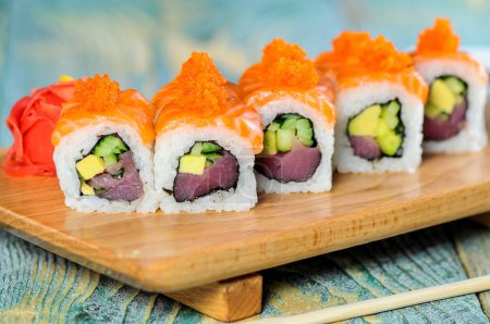 Foto de Cocina japonesa, rollos de sushi con salmón, atún, pepino y aguacate - Imagen libre de derechos