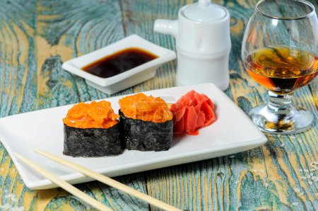 Téléchargez les photos : Un ensemble de rouleaux de sushis épicés. Rouleaux Maki avec boisson alcoolisée - en image libre de droit