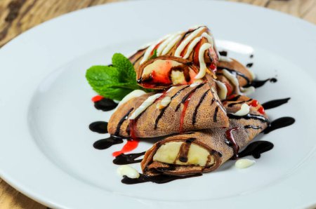Foto de Tortitas con chocolate y plátano en un plato blanco - Imagen libre de derechos