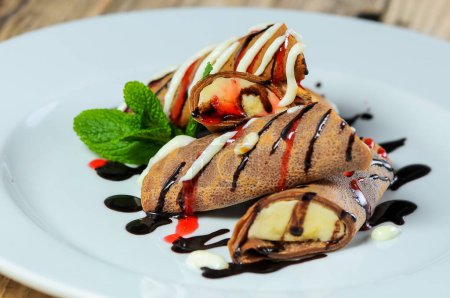Foto de Tortitas con chocolate y plátano en un plato blanco - Imagen libre de derechos
