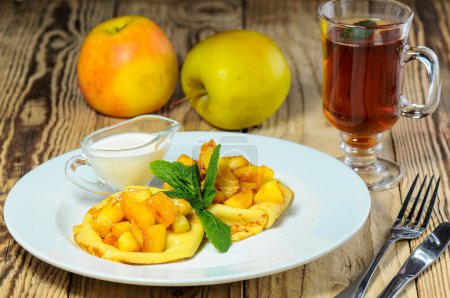 Foto de Deliciosos panqueques con manzanas y bebida en el fondo, de cerca - Imagen libre de derechos