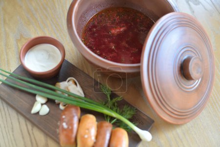 Téléchargez les photos : Petits pains savoureux et bortsch rouge avec de la viande sur une table en bois, gros plan - en image libre de droit