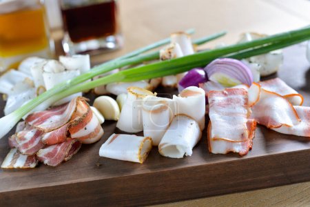 Téléchargez les photos : Bacon tranché de différents types sur une planche de bois aux oignons verts - en image libre de droit