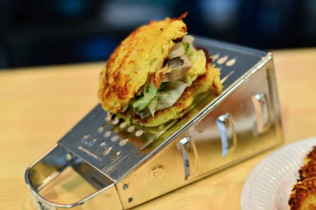 Photo for Big juicy fresh burger  with metal grater in the restaurant. - Royalty Free Image