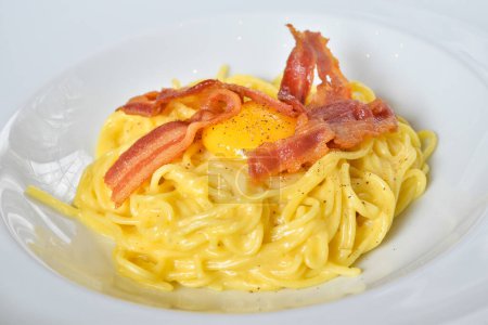 Téléchargez les photos : Pâtes traditionnelles italiennes Carbonara au bacon, fromage et jaune d'oeuf - en image libre de droit