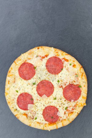 Photo for Pizza salami from above copyspace copy space portrait format on a slate vertical - Royalty Free Image