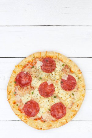 Photo for Pizza salami from above copyspace copy space portrait format on wooden board wood - Royalty Free Image