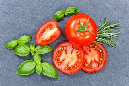 Photo for Tomatoes tomatos vegetables with basil from above on a slate from above - Royalty Free Image