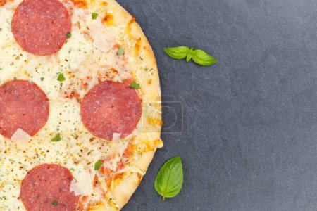 Photo for Pizza salami from above copyspace copy space close up on a slate - Royalty Free Image
