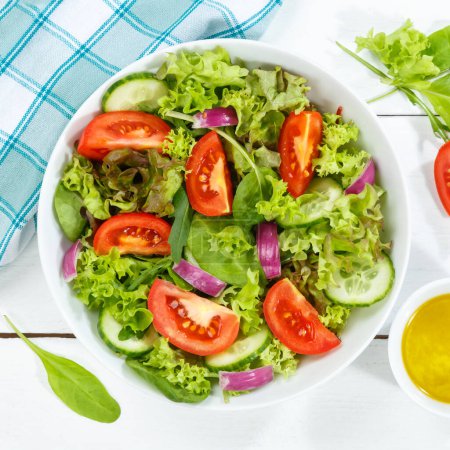 Foto de La ensalada mezclada con los tomates frescos que comen sano comen de arriba cuadrado en la tabla de madera - Imagen libre de derechos