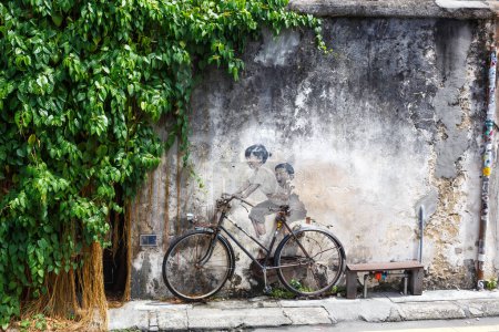 Foto de Arte callejero mural niño y niña en bicicleta en una pared en George Town en la isla de Penang en Malasia - Imagen libre de derechos