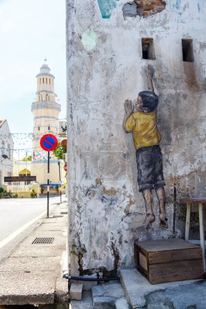Téléchargez les photos : Street Art mural garçon Atteindre sur un format de portrait mural à George Town sur l'île de Penang en Malaisie - en image libre de droit