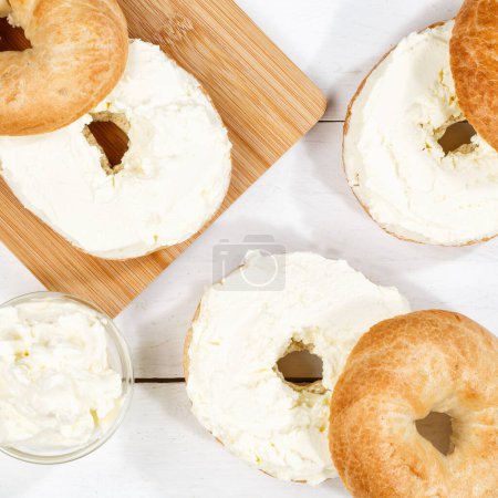 Foto de El bocadillo de rosquillas con el queso fresco de crema para el desayuno de arriba en la escuadra de madera - Imagen libre de derechos