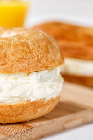 Foto de Sandwich de bagel con queso crema fresco para el desayuno de cerca el formato de retrato - Imagen libre de derechos