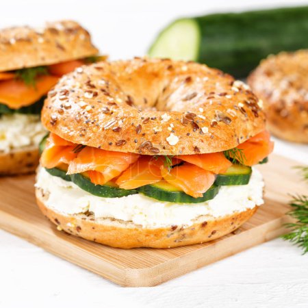 Photo for Bagel sandwich with salmon fish and cream cheese for breakfast on a kitchen board square - Royalty Free Image