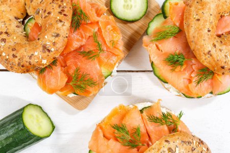 Photo for Bagel sandwich with salmon fish and cream cheese for breakfast on a wooden board from above - Royalty Free Image