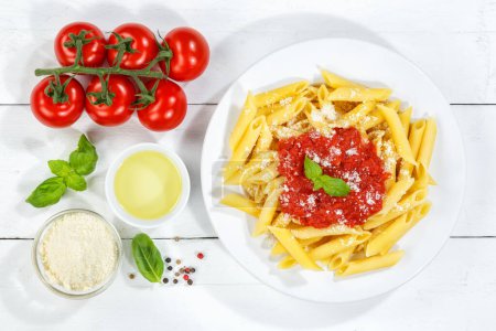 Photo for Penne Rigatoni Rigate pasta top view eat meal from Italy lunch with tomato sauce on a plate - Royalty Free Image