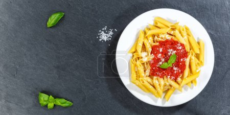 Photo for Penne Rigatoni Rigate pasta top view meal from Italy eat lunch with tomato sauce copyspace copy space panorama slate on a plate - Royalty Free Image