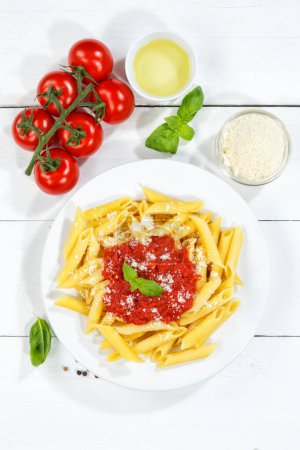 Photo for Penne Rigatoni Rigate pasta top view meal from Italy eat lunch with tomato sauce on a plate portrait format - Royalty Free Image