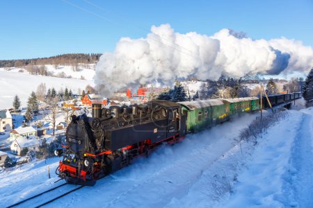 Foto de Sehmatal, Alemania - 18 de diciembre de 2022 Fichtelbergbahn tren de vapor locomotora ferroviaria en invierno en Sehmatal, Alemania. - Imagen libre de derechos