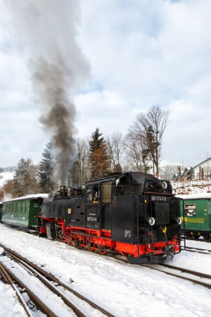 Foto de Oberwiesenthal, Alemania - 17 de diciembre de 2022 Fichtelbergbahn steam train locomotive railway in winter portrait format in Oberwiesenthal, Alemania. - Imagen libre de derechos