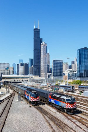 Foto de Chicago, Estados Unidos - 3 de mayo de 2023: Skyline with METRA commuter rail trains public transport near Union Station portrait format in Chicago, Estados Unidos. - Imagen libre de derechos