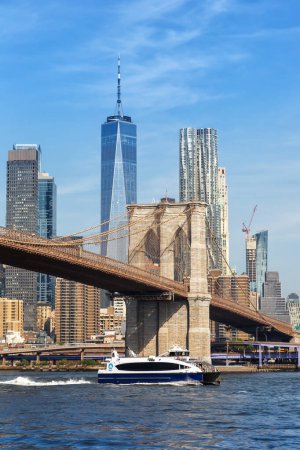 Photo for New York City skyline of Manhattan with Brooklyn Bridge, World Trade Center skyscraper and ferry portrait format traveling in the United States - Royalty Free Image