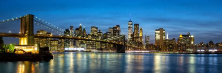 Photo for New York City skyline of Manhattan panorama with Brooklyn Bridge and World Trade Center skyscraper at twilight night in the United States - Royalty Free Image