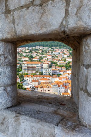 Foto de Vista del casco antiguo de Dubrovnik a través de una abertura en la pared del formato de retrato de la fortaleza que viaja por Croacia - Imagen libre de derechos
