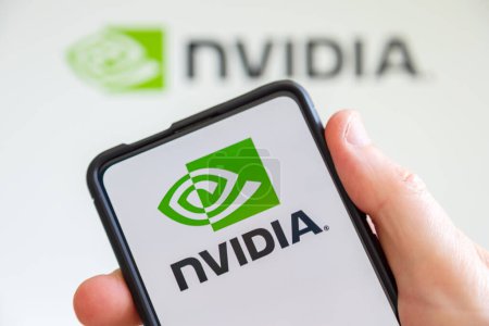 Photo for Stuttgart, Germany - July 20, 2023: Hand holding a mobile phone with Nvidia logo of the software company which designs graphics processing units GPU computer screen in Stuttgart, Germany. - Royalty Free Image