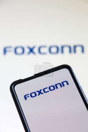 Téléchargez les photos : Stuttgart, Allemagne - 20 juillet 2023 : Logo Foxconn du producteur d'ordinateurs sur un téléphone portable et un écran à Stuttgart, Allemagne. - en image libre de droit