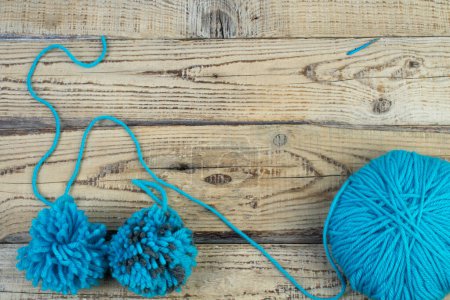 Photo for Skein of blue threads for knitting on a wooden background. pompon. fluffy soft pompon made of yarn - Royalty Free Image