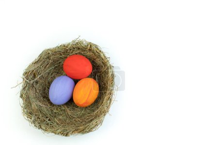 Foto de Feliz Pascua. Vista superior del nido con huevos de colores, aislados sobre fondo blanco. Copiar espacio para texto - Imagen libre de derechos
