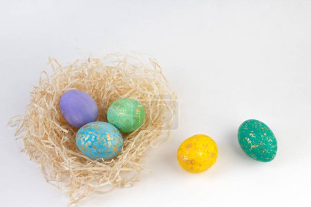 Foto de Feliz tarjeta de Pascua. Huevos brillantes de colores en un nido aislado sobre un fondo blanco. Copiar espacio para texto - Imagen libre de derechos