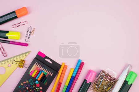 Foto de De vuelta a la escuela. Papelería sobre una mesa rosa. Escritorio de oficina con espacio para copias. Puesta plana - Imagen libre de derechos