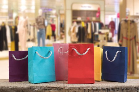Téléchargez les photos : Beaucoup de sacs à provisions multicolores en papier sur une table en bois dans un magasin. Vue de face - en image libre de droit